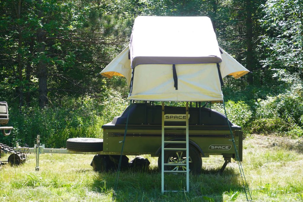 tent on top of green space trailer with wheel jack