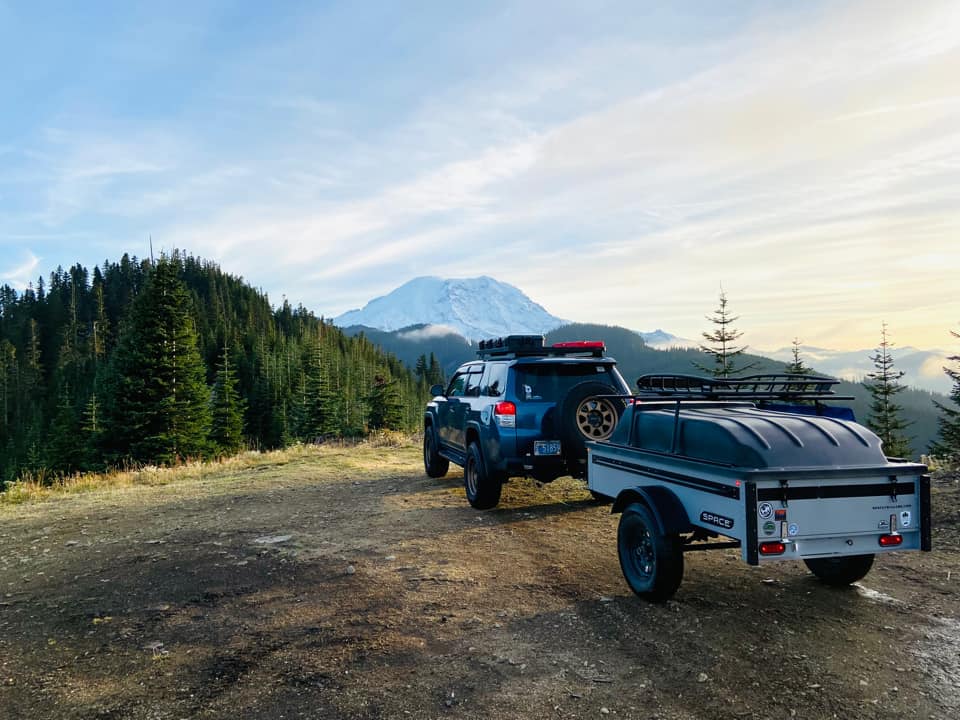 Gray space trailer being pulled through the mountains at sunrise