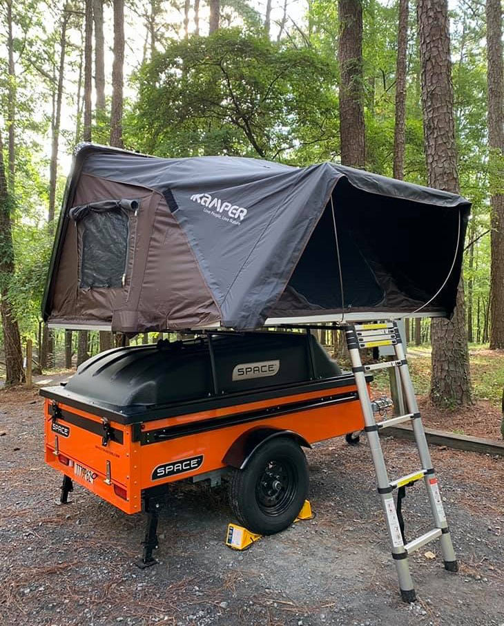Orange Space Trailer using Rear Stabilizer jacks with rooftop tent