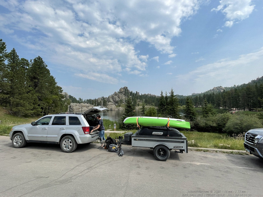 Gray space trailer with green kayak on top